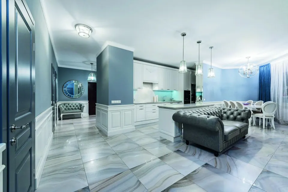 An open-plan living room with a layered false ceiling and a sculptural chandelier