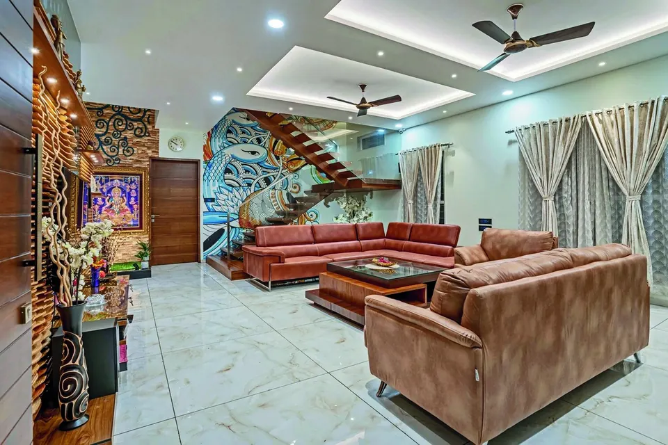 A traditional family living room with a wood-panelled staircase and terracotta sofas